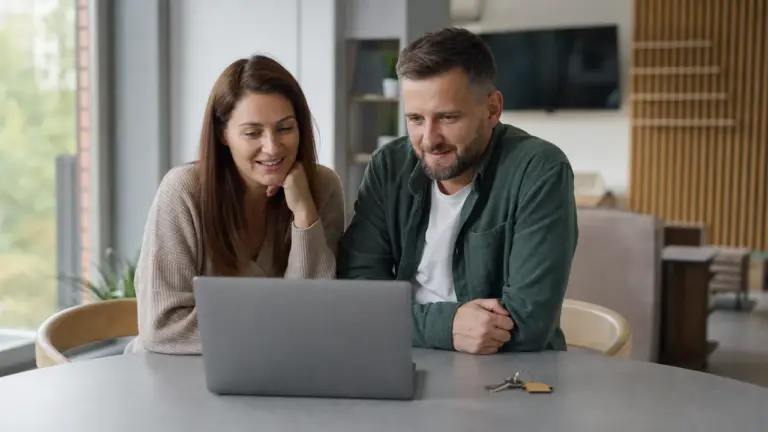 Couple comparant une simulation de prêt immobilier avec des clés
